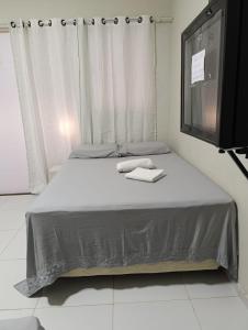 a bed with a television and two towels on it at Pousada Cajueiro in Juazeiro do Norte