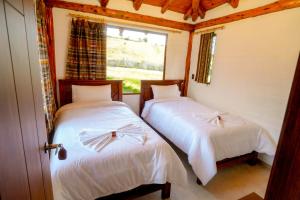 two beds in a room with a window at Taytapak Wasi in Riobamba +2 photos