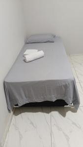a bed with a gray comforter in a room at Pousada Cajueiro in Juazeiro do Norte