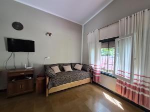 a living room with a couch and a tv and a window at Oasis in Villa Anizacate