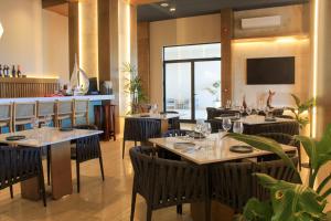 een restaurant met tafels en stoelen en een groot raam bij Creta Luxury Apartment, dining, fitness & leisure On-Site in Progreso