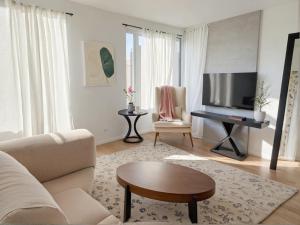 a living room with a couch and a flat screen tv at Stylish Urban Escape in Downtown Los Angeles in Los Angeles