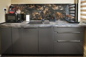 a kitchen with a sink and a counter top at Independentei Central Apartaments in Iaşi