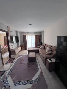 a living room with a couch and a tv at Tiba Golden Resort in Hurghada