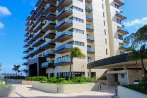 een hoog gebouw met palmbomen ervoor bij Creta Luxury Apartment, dining, fitness & leisure On-Site in Progreso