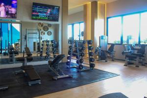 een fitnessruimte met loopbanden en cardio-apparatuur in een gebouw bij Creta Luxury Apartment, dining, fitness & leisure On-Site in Progreso