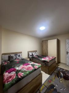 a bedroom with two beds with flowers on them at Tiba Golden Resort in Hurghada