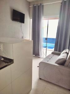 ein Schlafzimmer mit Bett, Fernseher und Fenster in der Unterkunft Flat Coqueirinho in Conde