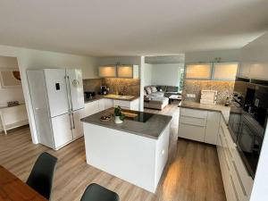 a kitchen with white cabinets and a white refrigerator at Family Beach Appartement Laboe in Laboe +7 photos