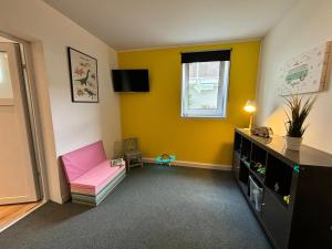 a living room with a pink couch and a window at Family Beach Appartement Laboe in Laboe