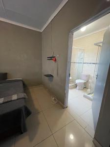a bathroom with a door open to a bathroom with a toilet at Mbombela Stay in Nelspruit