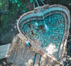 a swimming pool with blue rocks and a water hose at L essenCiel in Saint-Claude