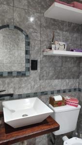 Un baño con lavabo blanco y inodoro. en Casa vacacional 6 personas, en Santa Teresita 7 fotos más