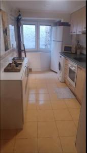 a kitchen with white appliances and a tile floor at Casa del bienestar in Bermeo +2 photos