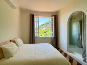 a bedroom with a white bed and a window at Casa Rocha in Rio de Janeiro