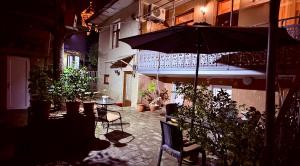 un patio con una mesa y una sombrilla en SDD Brothers - Дом с балконом в сердце Тбилиси, en Tiflis