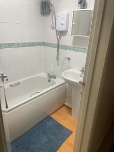 a bathroom with a bath tub and a sink at Bridgewater Court 2 in Southampton