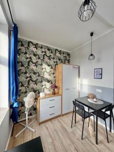 a dining room with a table and a cabinet at Przy Parku Róż II in Chorzów