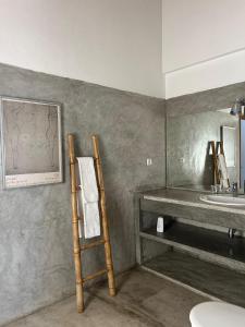 Un baño con una escalera, un lavabo y un espejo. en Monte dos Pensamentos - Turismo Rural, en Estremoz