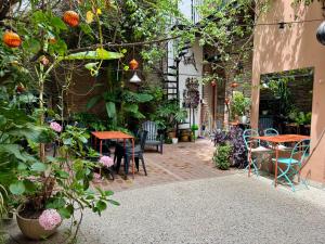 Lina's Tango Guesthouse في بوينس آيرس: فناء به طاولات وكراسي ونباتات