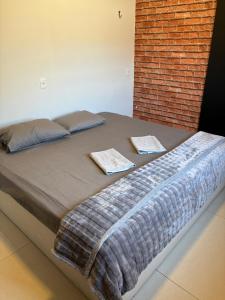 a large bed with two pillows and a brick wall at Espaço Atlântico in Goiânia +43 photos