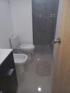 een witte badkamer met toilet en douche bij ChicPDD in Punta Del Diablo +6 foto's