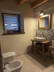 a bathroom with a toilet and a sink and a window at Naš duam in Stregna