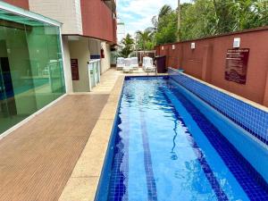a swimming pool next to a building at Flat no Centro de Campo Grande in Campo Grande