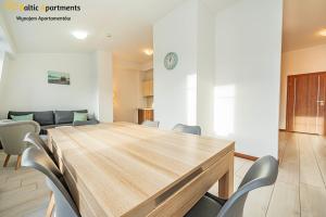 a dining room with a wooden table and chairs at Baltic Apartments - Apartamenty Aquamarina in Świnoujście