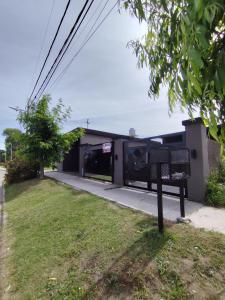 un edificio con un banco en el césped en Casa vacacional 6 personas, en Santa Teresita