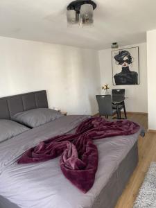a bedroom with a bed with a purple blanket on it at New komplett möblierte Wohnung-Zentral in Sindelfingen