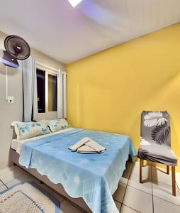 a bedroom with a blue bed and a yellow wall at #FInALdeSeMaNaTop em Matinhos a 50m da PrAiA in Matinhos