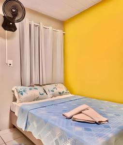 a bedroom with a bed with a yellow wall at #FInALdeSeMaNaTop em Matinhos a 50m da PrAiA in Matinhos +4 photos