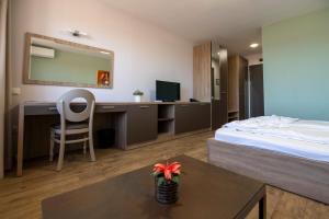 a hotel room with a bed and a desk with a mirror at Hotel LaCasa Tsigov Chark in Batak