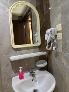 ein Badezimmer mit einem weißen Waschbecken und einem Spiegel in der Unterkunft Jazirat Al Balad in Muzdalifah