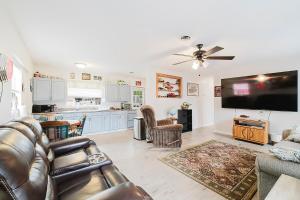 uma sala de estar com um sofá e uma TV de tela plana em Little red house with vintage, retro feel to it! em Ocala