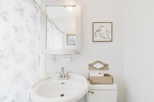 um banheiro branco com uma pia e um vaso sanitário em Little red house with vintage, retro feel to it! em Ocala mais 26 fotografias