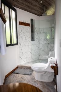 a bathroom with a white toilet and a shower at Quality Cabins Monteverde in Monteverde Costa Rica +100 photos