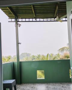 a green wall with a bench and palm trees at Gangi Kota Penthouse in Kovvūr