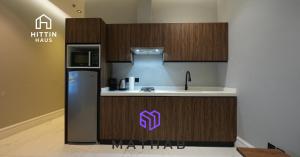 a kitchen with a sink and a refrigerator in a room at Hittin Haus in Riyadh