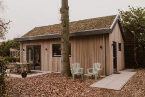 una piccola cabina con due sedie e un albero di De Eikenloft a Heerenveen