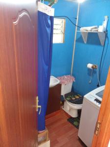 un bagno blu con un water e una porta di Cabaña carmen velasquez a Pargua