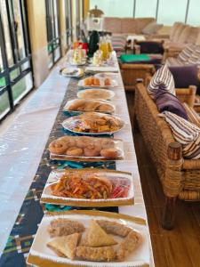 Una mesa larga cubierta con platos de comida en Chula Beach Resort, en Mbita