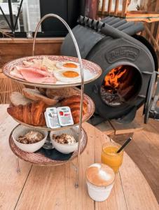 Una bandeja de pan y pasteles junto a una estufa. en SandCsleep, en Katwijk 10 fotos más