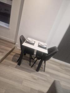 una mesa y dos sillas negras en una habitación en Modern 1-Bed in Victorian Building, Bury, en Bury