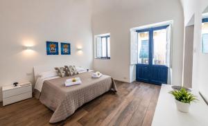 una camera bianca con un letto e una grande finestra di Terrazza in Centro - Casa Torres ad Acireale