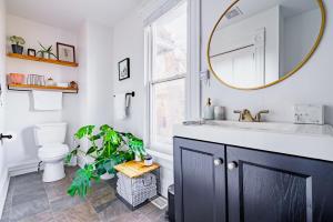 un baño con lavabo y espejo en Jungle House Luxury Homes - Columbus Downtown Short North - Steps to Convention Center & Nationwide Arena - Sleeps up to 11 - Free Parking - Over 5,800 Five Stars, en Columbus