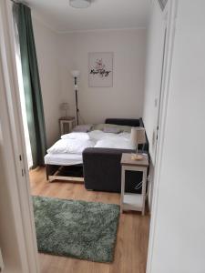 a bedroom with a bed and a table with a couch at Tímea Apartman Pécs in Pécs