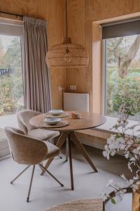 un tavolo e delle sedie in una stanza con una finestra di De Eikenloft a Heerenveen