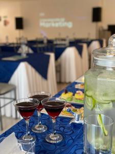 three glasses of red wine on a blue table at Navio Hotel in Manta